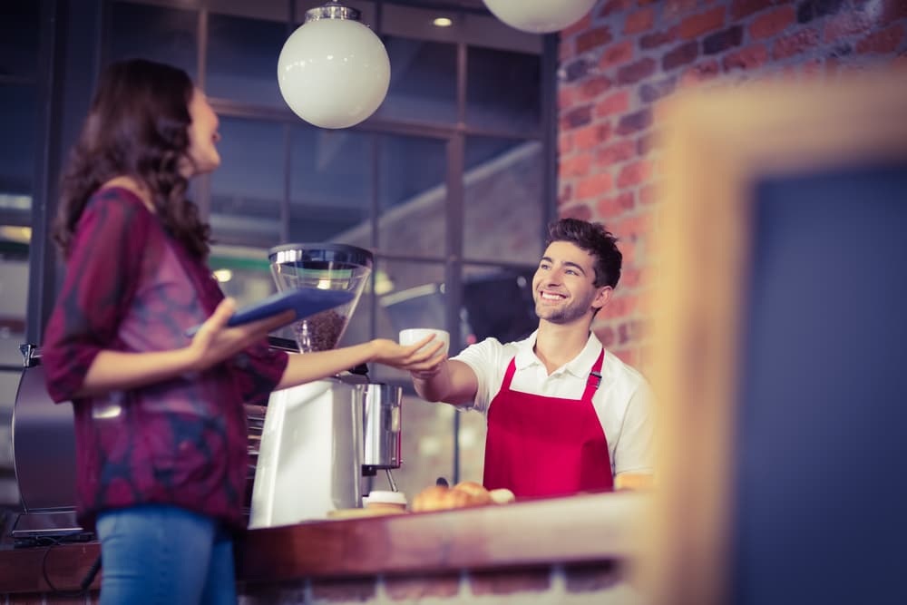 A hospitality worker carrying coffee